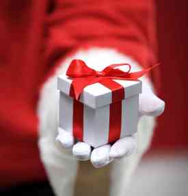 photo-of-santa-claus-gloved-hands-holding-white-giftbox